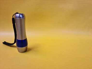 Modern tasarımı olan kompakt LED bir fener, arka güç anahtarı ve bilek kayışı, açık hava kullanımı için uygun..