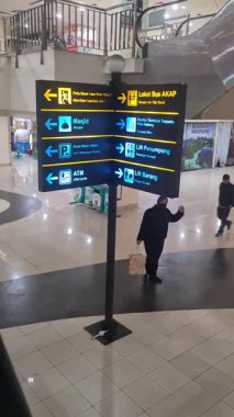 Jakarta, Endonezya - 21 Haziran 2025: Yukarı doğru kayan bir çekim, siyah bir üsteki aydınlatma metniyle parıldayan bir yön işareti ortaya çıkararak, parlak ve modern bir kentsel navigasyon sahnesi oluşturdu.