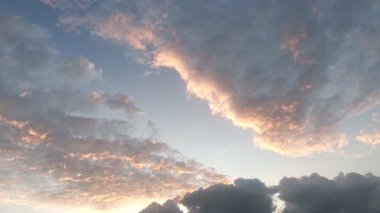 Güneş doğarken hareket eden kara bulutların zamanı, dramatik gökyüzünde yavaşça sıcak güneş ışığını açığa çıkarıyor, doğa ve hava görüntüleri için mükemmel..