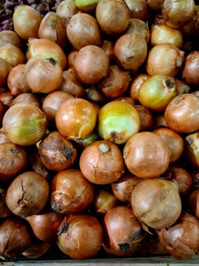 Yığınla taze sarı soğan yığını. Kağıtlı soğanların yakın çekimi, gıda, pazar, tarım ve mutfak içeriği için ideal.