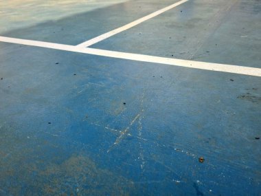 Mavi branda yüzeyindeki beyaz çizgi, doğal aydınlatma altında doku kontrastı ve sentetik materyal detaylarını gösteriyor.