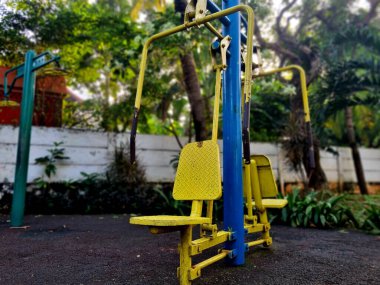 Kol ve üst vücut egzersizi için sarı göğüs pres makinesi. Kamu sağlık ekipmanları açık park alanında kullanıma hazır.