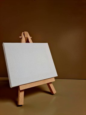 Bej arkaplana karşı duran boş beyaz tuval, sanat, model, yaratıcılık veya minimalist tasarım temaları için ideal.