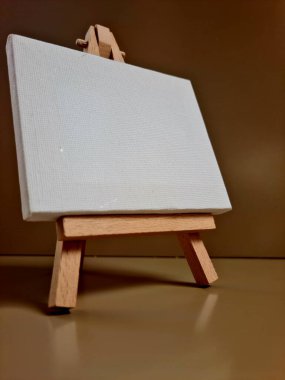 Bej arkaplana karşı duran boş beyaz tuval, sanat, model, yaratıcılık veya minimalist tasarım temaları için ideal.