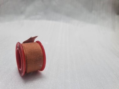 Düzgün yerleştirilmiş bir sargı rulosu, ilk yardım veya yara bakımı için kullanılmaya hazır. Temiz ve minimal tıbbi malzeme atışı.