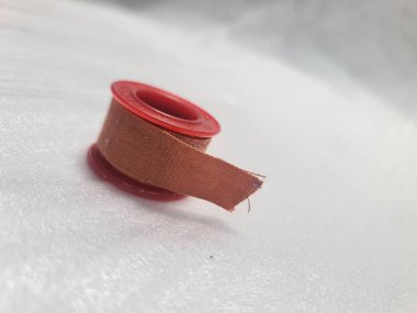 Düzgün yerleştirilmiş bir sargı rulosu, ilk yardım veya yara bakımı için kullanılmaya hazır. Temiz ve minimal tıbbi malzeme atışı.