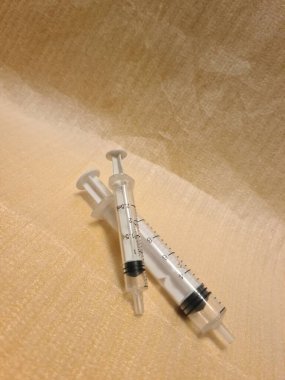 Temiz yüzeyde iğnesiz boş şırınga. Şeffaf namlulu tıbbi enjeksiyon aracı, kullanılmamış ve hazırlamaya ya da imha etmeye hazır.