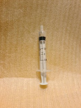 Temiz yüzeyde iğnesiz boş şırınga. Klinik ya da sağlık ortamlarında kullanım ya da imha için hazırlanmış şeffaf tıbbi şırınga.