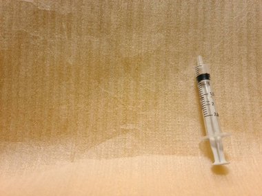 Temiz yüzeyde iğnesiz boş şırınga. Klinik ya da sağlık ortamlarında kullanım ya da imha için hazırlanmış şeffaf tıbbi şırınga.