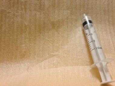 Temiz yüzeyde iğnesiz boş şırınga. Klinik ya da sağlık ortamlarında kullanım ya da imha için hazırlanmış şeffaf tıbbi şırınga.