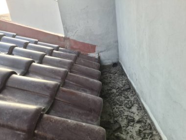 Yüzeyinde kurumuş yosun ve lekeler olan kirli oluk. İnşaat, dış bakım ve arka plan kullanımı için eski su boşaltma borusu detaylarını gösteriyor..