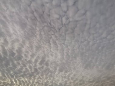 Güneşin doğuşunun çarpıcı çatlaklarıyla bulutlu bir gökyüzü.