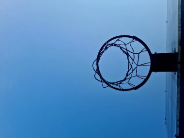 Mavi gökyüzü arka planına sahip basketbol potası, oyun, eğitim ve oyun alanı tasarımı için açık hava spor ekipmanları.