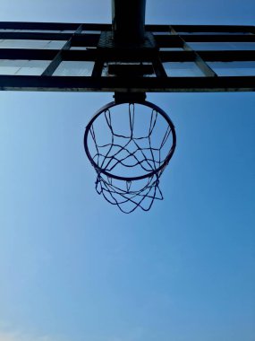 Mavi gökyüzü arka planına sahip basketbol potası, oyun, eğitim ve oyun alanı tasarımı için açık hava spor ekipmanları.