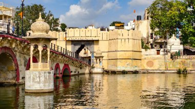 Eski köprü manzarası ve tarihi mimari göl suyu, Udaipur, Rajasthan, Hindistan, Ağustos 2025 'e yansıyor. Kubbeleri ve kemerleri olan geleneksel Rajasthani tarzı.