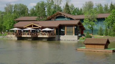 Durgun sulara uzanan sazlıklar üzerine kurulmuş konuklara dışarıda uzun ağaçların arasında akşam yemeği yediriyorlar.