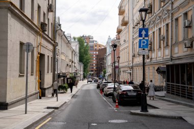Geleneksel mimari ve park halindeki arabaların yer aldığı canlı ve canlı bir şehir caddesinin çarpıcı manzarası.