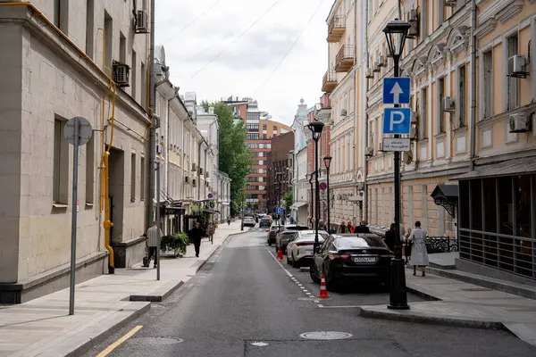 Geleneksel mimari ve park halindeki arabaların yer aldığı canlı ve canlı bir şehir caddesinin çarpıcı manzarası.