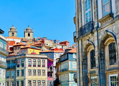 Porto, Portekiz 'in göbeğinde parlak mavi gökyüzü olan renkli tepe kenarlı evler ve tarihi mimari. Cazibe, miras ve Akdeniz enerjisiyle dolu canlı ve canlı bir sahne..