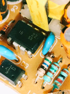 Entegre devreler, rezistanslar ve dönüştürücülerin yer aldığı bir PCB 'nin yakın çekimi. Elektronik, mikro mühendislik ve elektrik sistemlerini göstermek için kullanışlı.