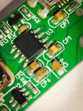 Yeşil bir PCB üzerinde etiketli küçük bir mikroişlemcinin detaylı makro görüntüsü. Teknoloji veya elektronik görseller için ideal.