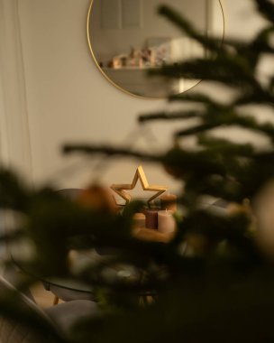 Odada altın mumlarla süslenmiş Noel ağacı