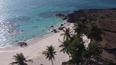 Bu nefes kesen, tozlu beyaz kumların kristal berrak turkuaz sularla buluştuğu bu gizli kumsalda dokunulmamış bir cennet parçası keşfedin.