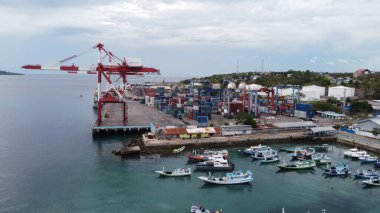 Doğu Nusa Tenggara, Endonezya 'nın güzel adalarındaki küçük bir limandan özgün bir manzara. Belirgin şekilleri ve canlı renkleriyle birkaç geleneksel Endonezya balıkçı teknesi durgun ve berrak turkuaz sulara demirlemiştir..