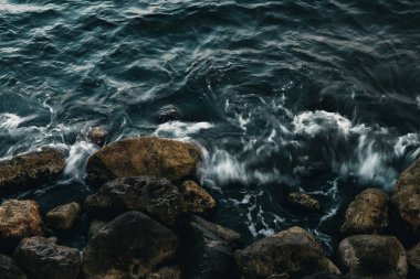 Dinamik dalgalar engebeli kayalara çarparak dramatik ve güçlü bir kıyı manzarası yaratır..