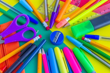 Kırtasiyeli çok renkli arkaplan, boyama ve okul için nesneler, makas, dolma kalemler, kalemler, kalemler, cetveller, kırmızı, sarı, yeşil renkler
