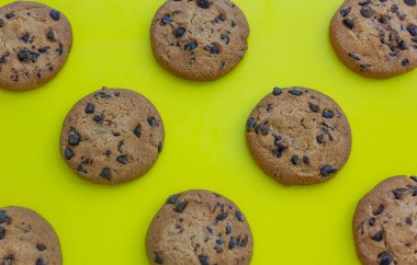 Sarı arka planda çikolatalı kurabiyeler, fotoğraf arkaplanı, tatlılar, pişirme, kurabiyeler