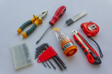 İnşaat araçları, beyaz arka plandaki tamir araçları, fotoğraf çektirme günü, bıçak, tornavida, pense, mezura, mezura, tornavida seti, matkaplar.