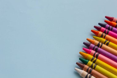 mavi kağıt üzerine çok renkli kalem ve kalemler yakın plan, fotoğraf arkaplanı, okula dönüş, metin için boş alan