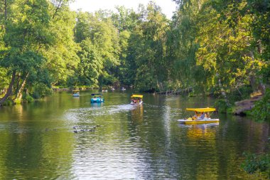 Katamaranlar ve tekneler gölün üzerinde yüzerler.