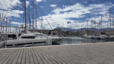 Palermo İtalya 18 Mart 2025. Palermos Foro Italico marinasındaki teknelerin ve yatların arka planında bulutlu bir gökyüzü olan trapezoidal iskeledeki görüntülerini rıhtımdan çek. 
