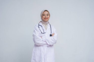 Beyaz önlüklü, kollarını kavuşturmuş güzel Asyalı kadın doktor.