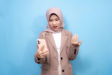 Beyaz arka planda akıllı telefon kullanan tesettürlü güzel, genç Müslüman bir kadın.