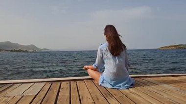 Güneşli bir günde dingin bir ahşap rıhtımda dinlenmek ya da meditasyon yapmak