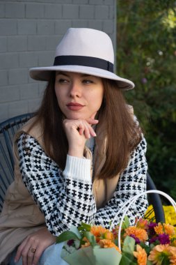 Şapkalı ve sonbahar elbiseli güzel, dalgın bir esmer..