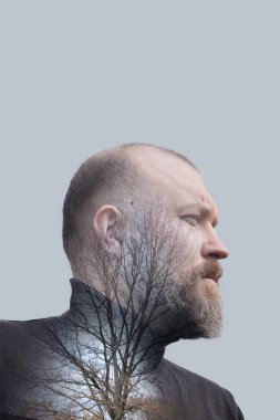 Çıplak bir ağacın silüetine sahip bir adamın profili, doğayla olan bağlantısını ve hayatı yansıtıyor..