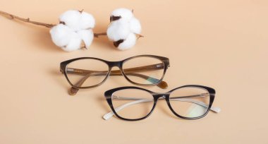 Bej arka planda pamuklu gözlük. Optik mağaza, görüş testi, şık gözlük konsepti