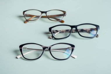 Yeşil arka planda şık gözlükler. Optik mağaza, görüş testi, şık gözlük konsepti