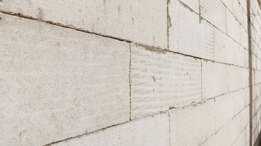Düzgün düzenlenmiş beyaz bir tuğla duvar. Sağ taraftan..