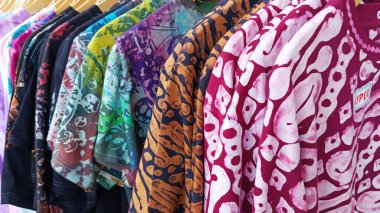 Vitrine dizilmiş boya desenli elbiseler..