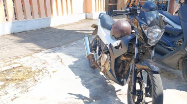 Bogo kasklı motosikletin önünde.