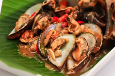 Muz yaprağıyla yamulmuş deniz ürünleri. Beyaz kabuklu deniz ürünleri. Midye ve istiridye gibi kızartılmış kabuklu deniz ürünleri. deniz ürünleri çok lezzetlidir.