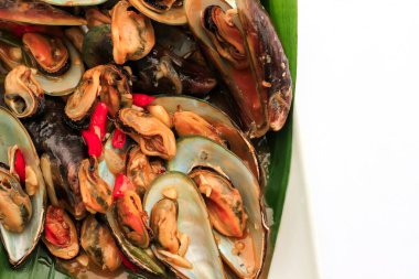 Kabuklu deniz hayvanları istiridye ve midye içerir. Beyaz kabuklu deniz ürünleri. Muz yaprağına sarılmış kızarmış kabuklu deniz ürünleri. deniz ürünleri çok lezzetlidir.