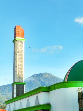 Kuningan, Endonezya 5 Ağustos 2024 - Yeşil cami kulesi ve arka planda mavi gökyüzü ve Ciremai Dağı olan kubbe