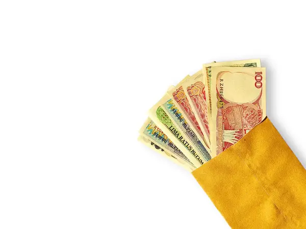 Eski rupiah banknotları kahverengi bir zarfın içinde, beyaz bir arka planda izole edilmiş..