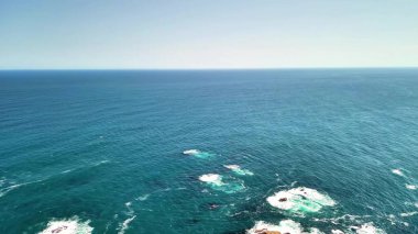 Kayalık kıyılar tarafından çerçevelenmiş uçsuz bucaksız bir su gövdesinin çarpıcı hava görüntüsü. Bu video, sakin yüzeyde yüzen tekneleri yakalıyor, doğayı ve eğlenceyi vurguluyor.